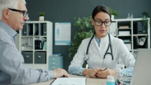 plano de saúde para idosos: Médico consultando um paciente idoso em um consultório